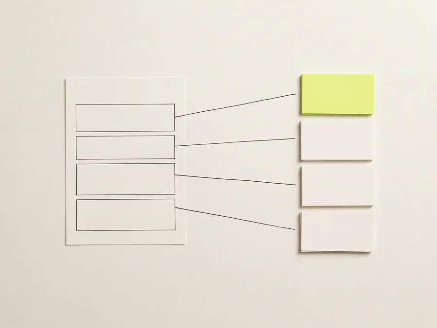A blank ruled form on the left with ink lines running from its fields across to a sorted column of cards, the top one lime.
